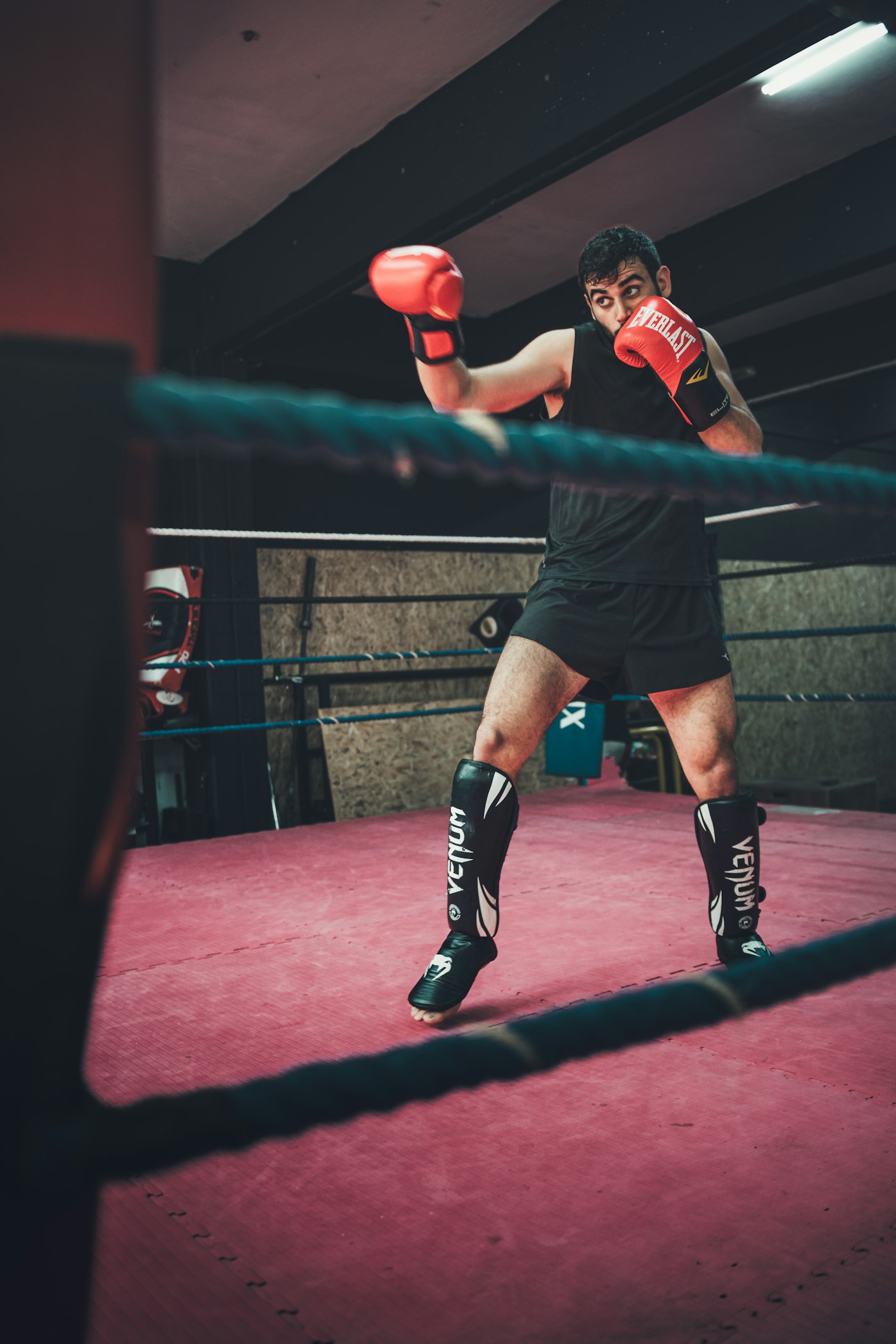 Boxer in a ring throwing a punch, full body from the back foot to the glove
