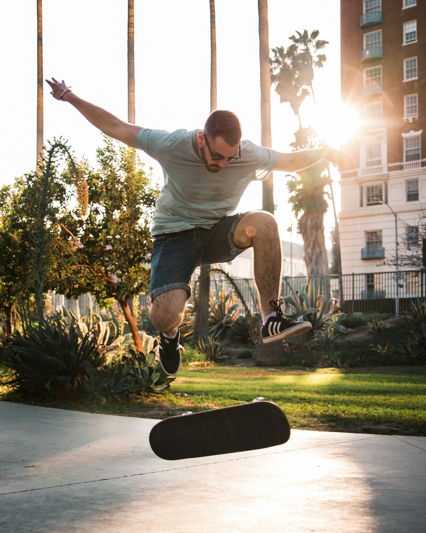Skateboarder losing his board and falling backwards with his arms flung out