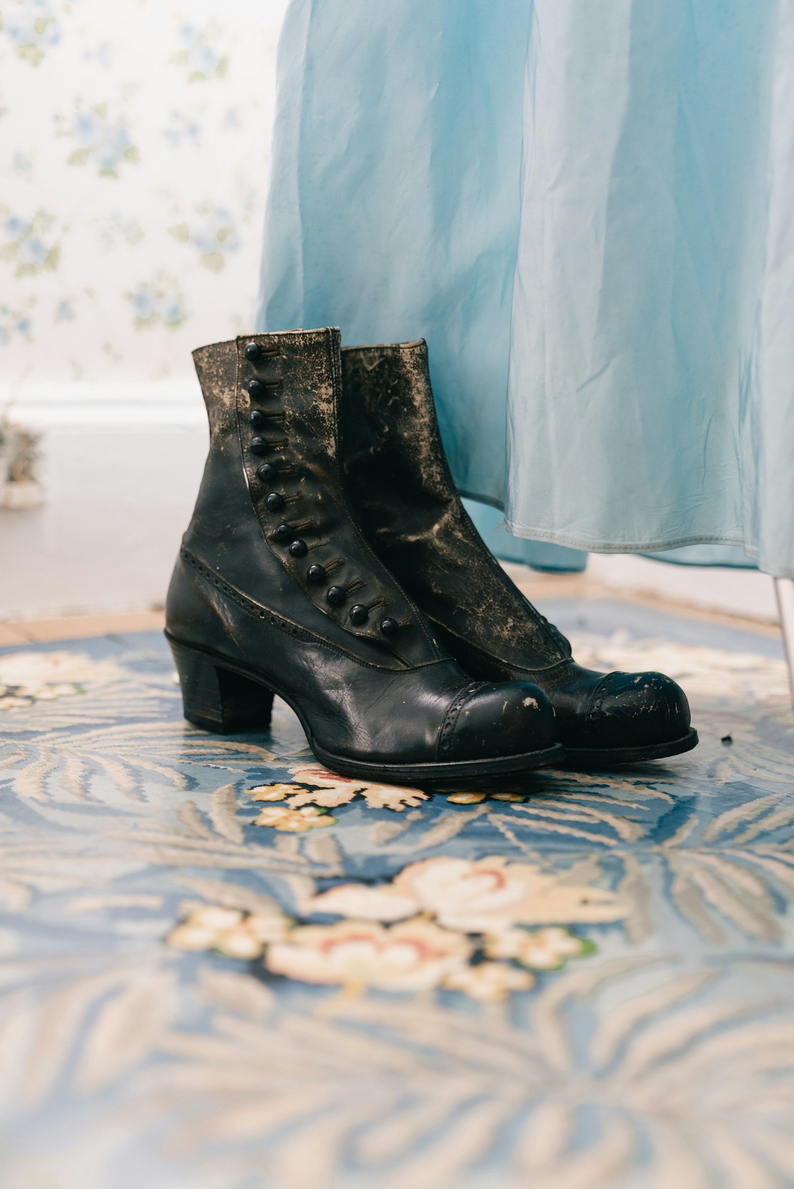 Vintage black button-up boots with a small heel on a floral rug