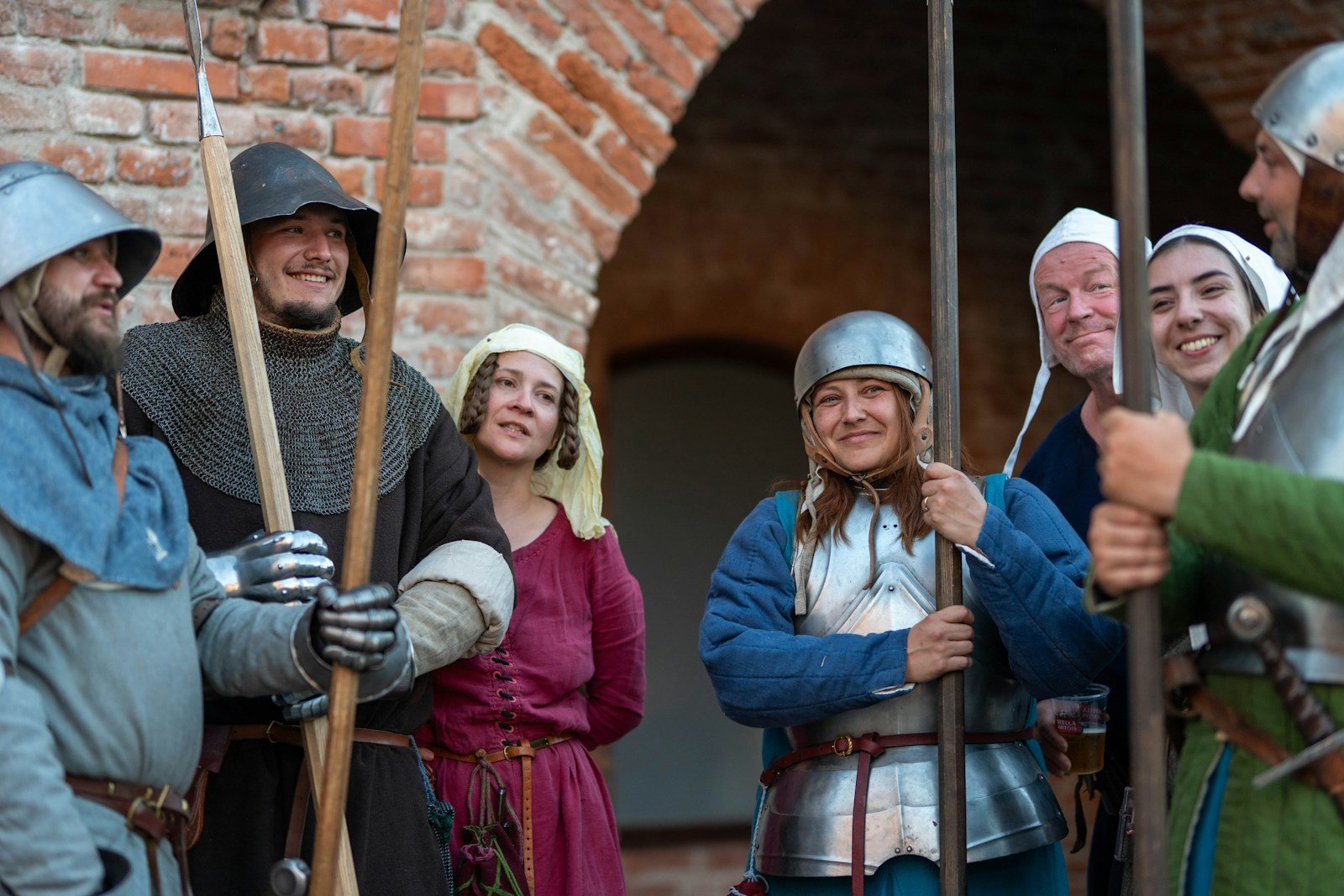 Group of medieval reenactors in armor holding spears upright, hands at different heights on the shafts
