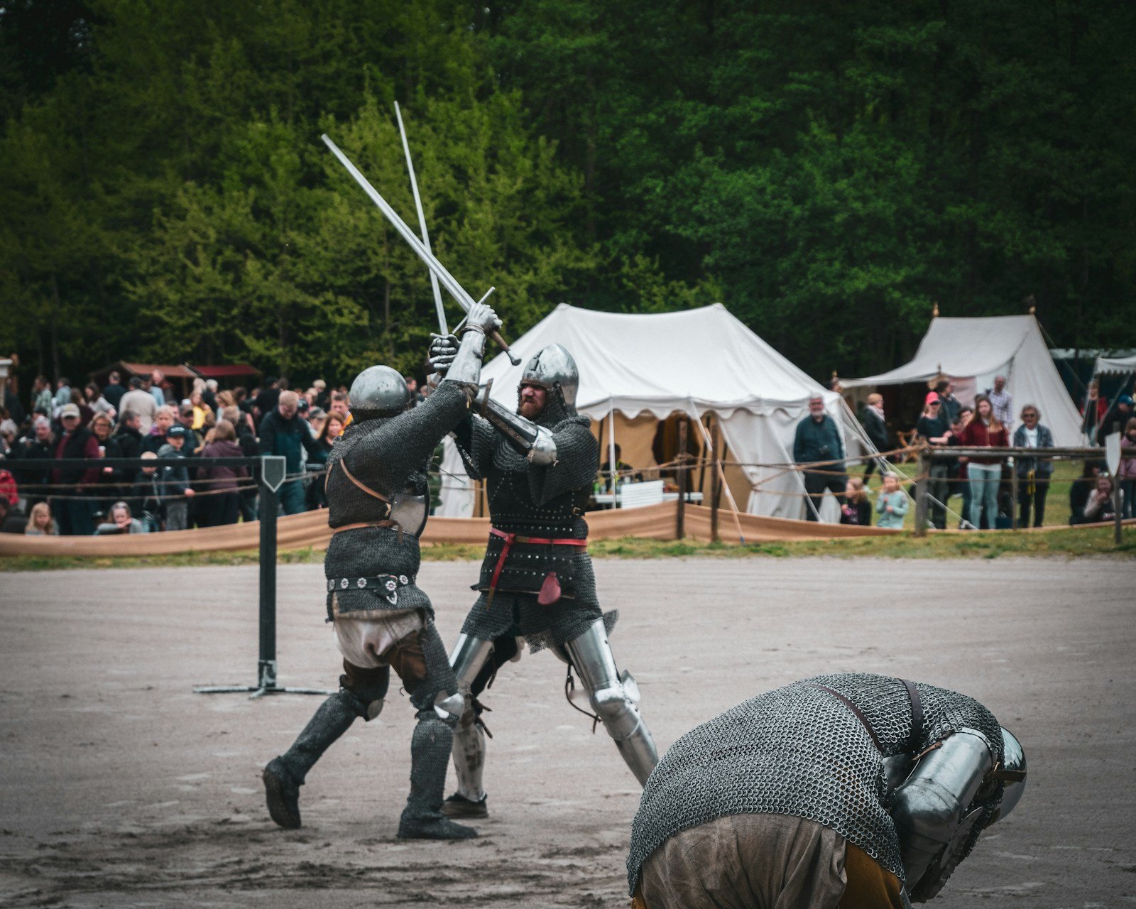 Two armored fighters at the moment their swords meet, both blades raised on a diagonal
