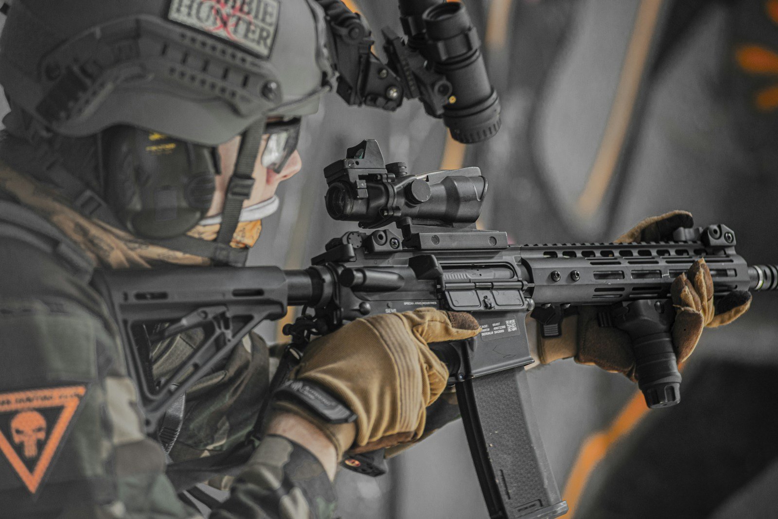 Close-up of gloved hands holding an airsoft rifle, the grip hand and the support hand visible